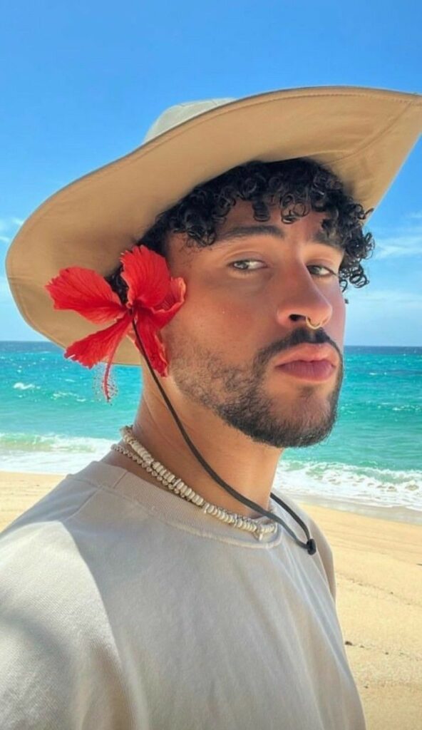 Bad bunny in the grey t-shirt pair with hat while taking a selfie and poses for a photo