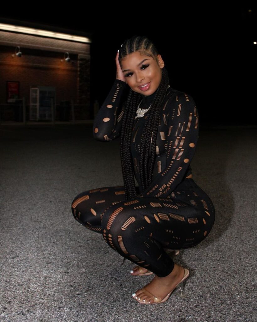Chrisean Rock in the black captivating outfit pair with matching heels while smiling towards camera