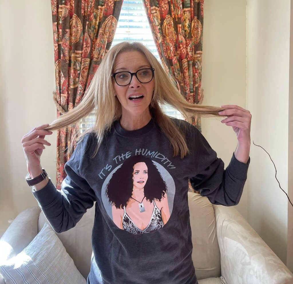 Lisa Kudrow in the black printed t-shirt pair with smart watch while poses for a photo