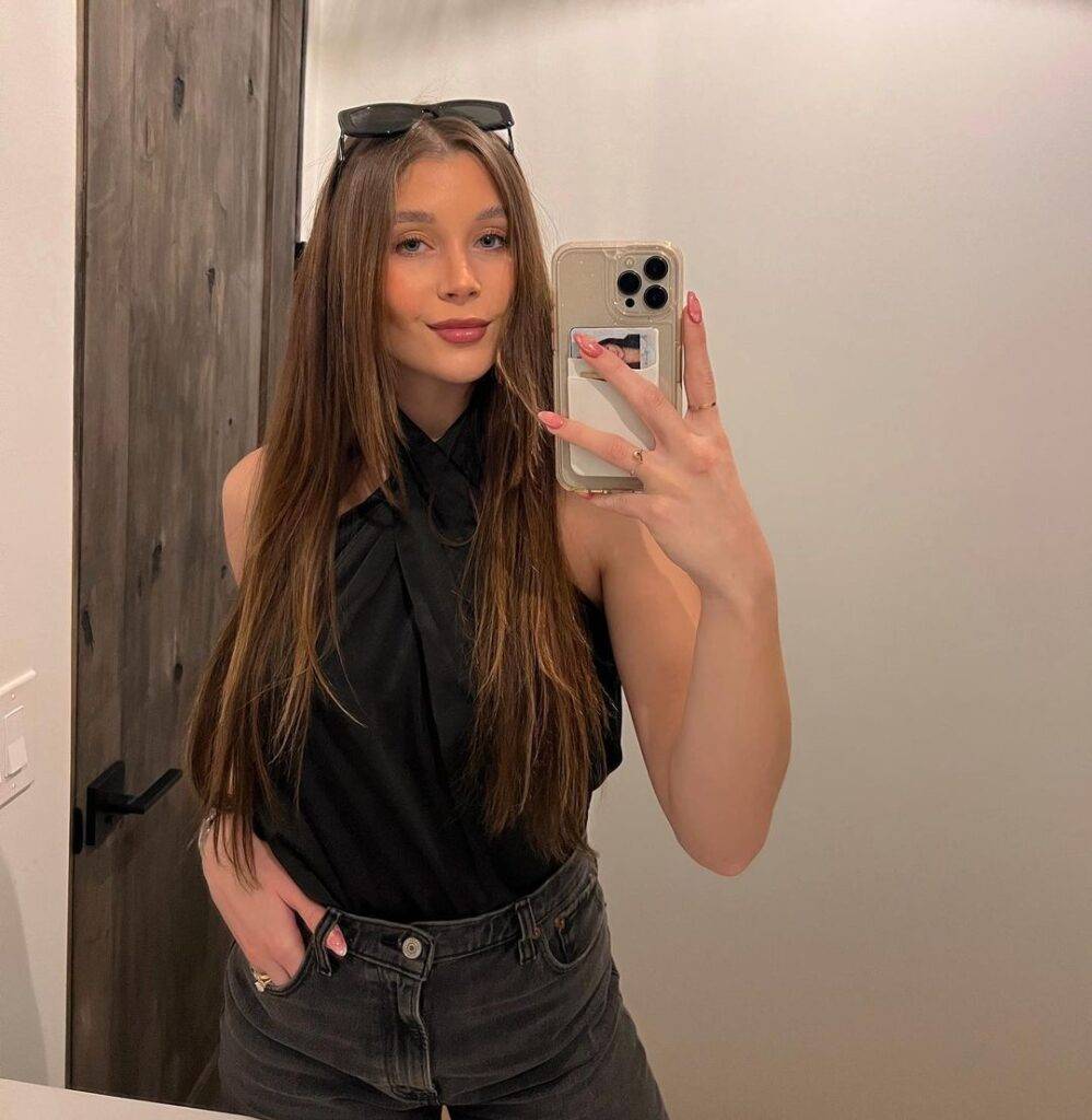 Marissa Layne Lawrence in the black sleeveless top pair with grey jeans while taking picture in the front of mirror