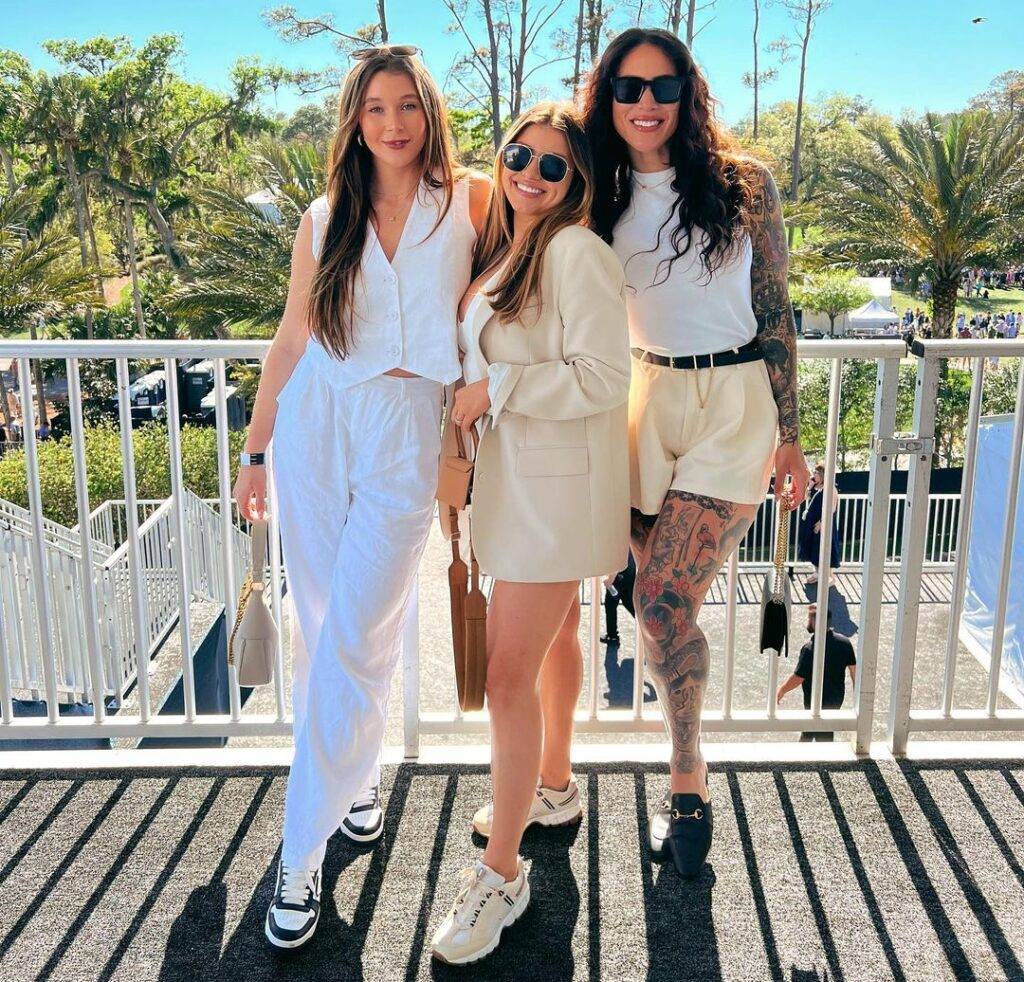 Marissa Layne Lawrence in the white beautiful top pair with matching pants and black and white joggers while smiling towards camera