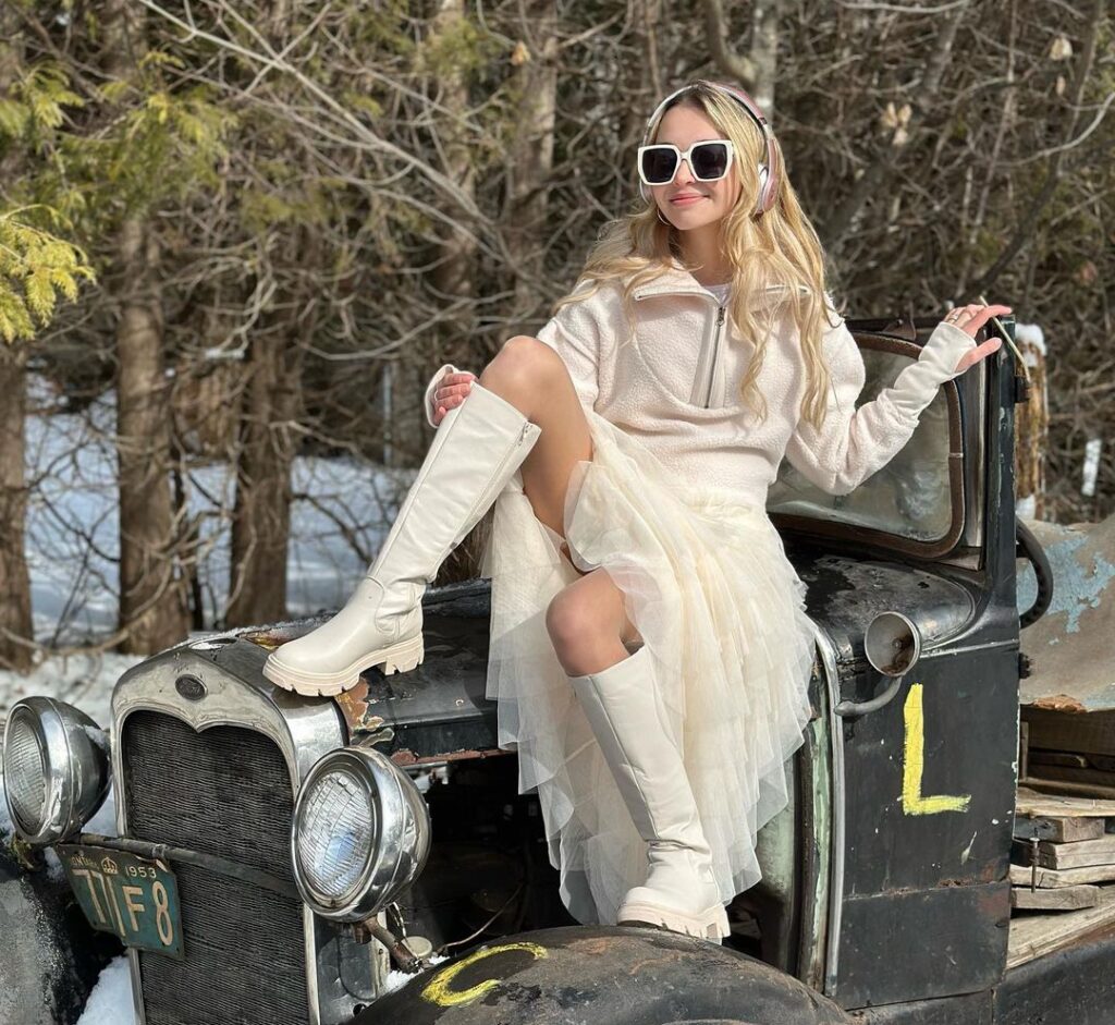 Nikki Roumel in the off white captivating outfit pair with matching shoes while poses for a photo
