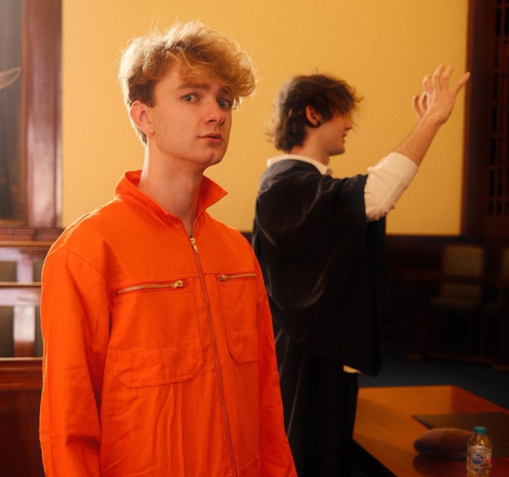 TommyInnit in the orange front zip shirt while looking towards camera for taking a picture