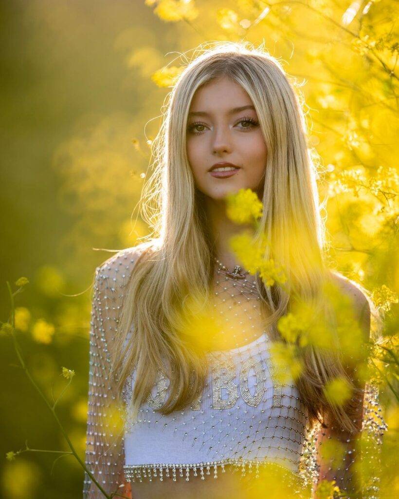 Emily Dobson in the white crop top while looking towards camera and poses for a photo