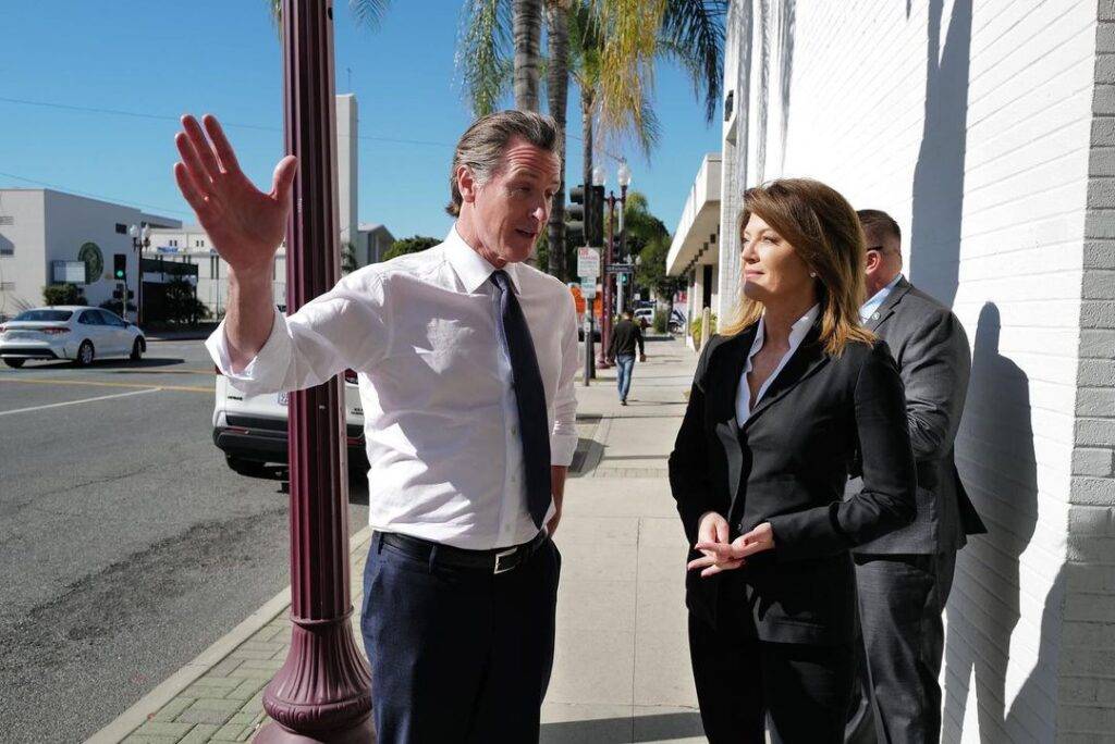 Norah O'Donnell in the black 3-piece suit while talking to his friend and poses for a photo