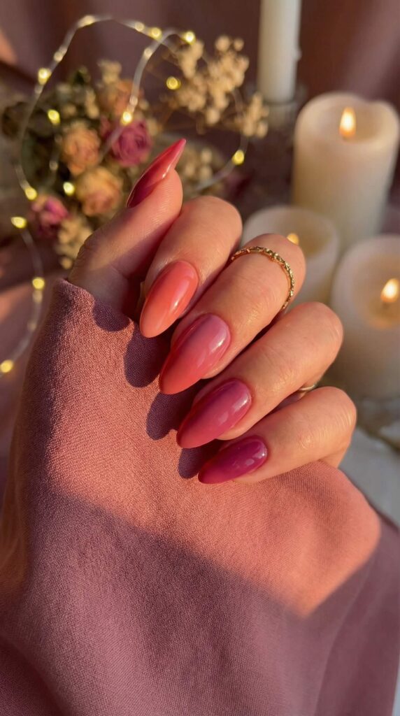 Sunset gradient ombre nails in coral, pink and mauve on almond-shaped nails