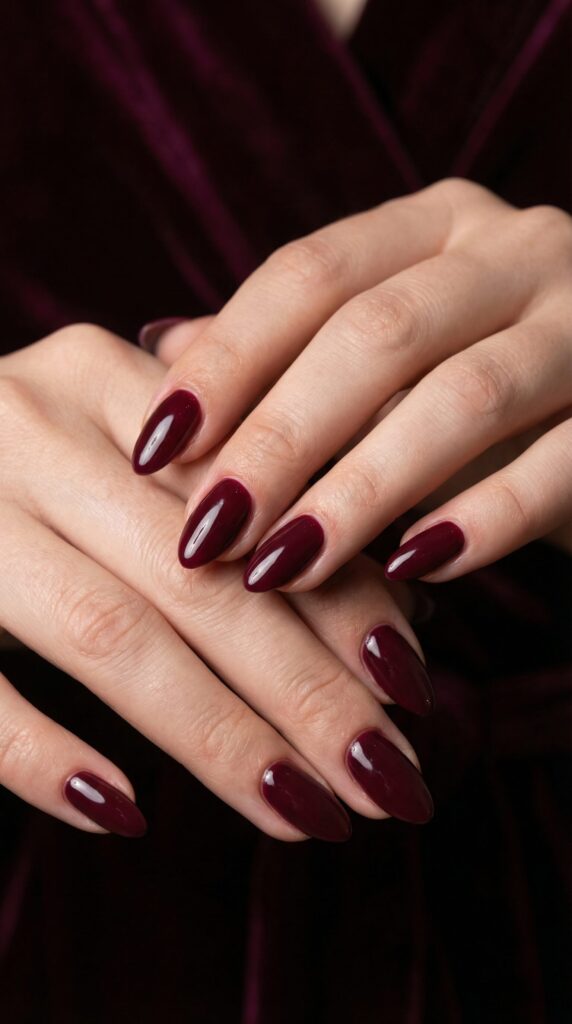 Deep burgundy wine-colored glossy nails on almond shape