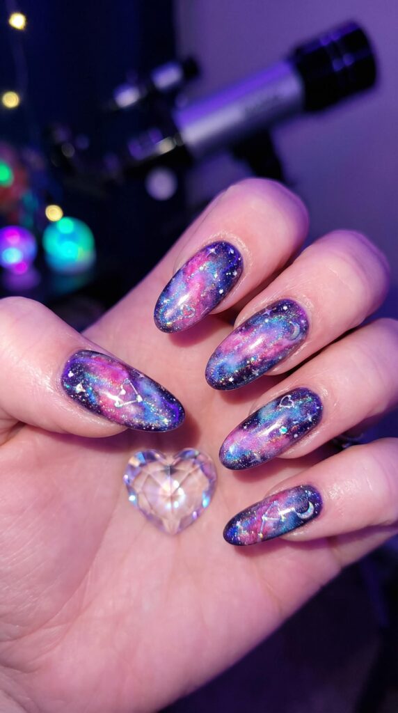 Galaxy nail art with pink and purple nebula design and constellation accents