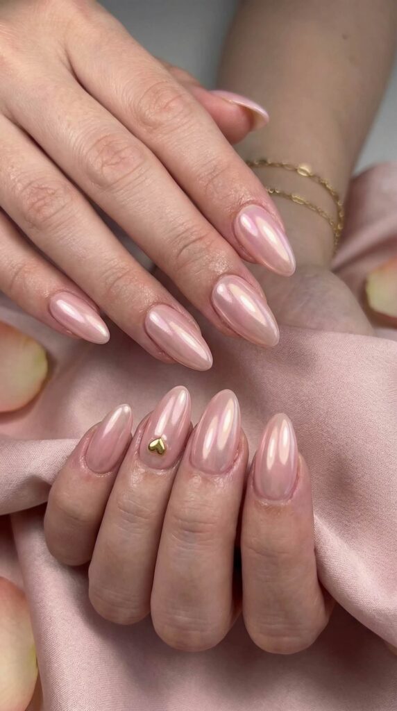 Glazed donut chrome nails in soft pink with gold heart charm accent