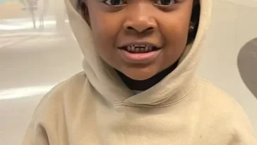 Baby Woo Wop in the off white hoodie pair with black pants while smiling towards camera