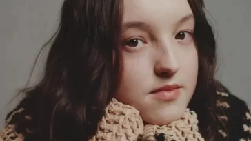 Bella Ramsey in the brown and black wool shirt while looking towards camera for taking a picture