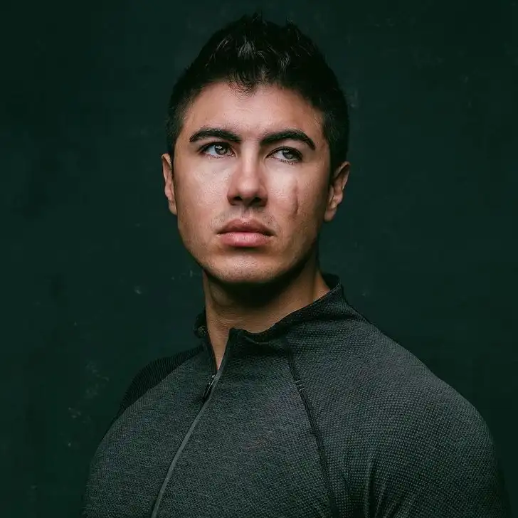 Damian Romeo in the black front zip shirt while looking towards camera for taking a picture