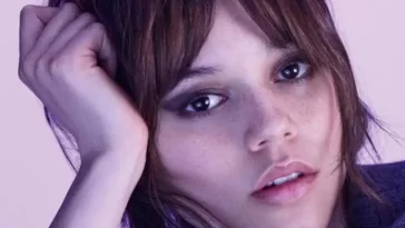 Jenna Ortega in the black sweatshirt while looking towards camera and poses for a photo