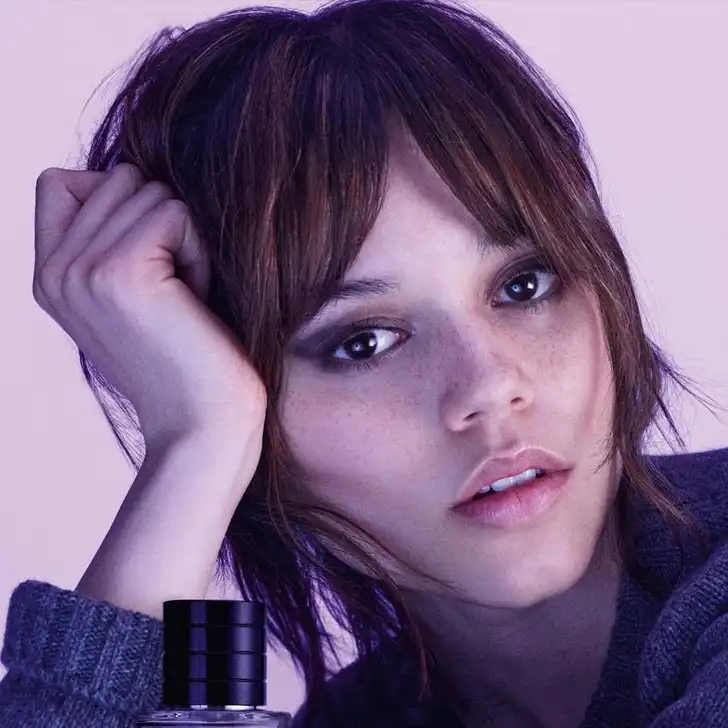 Jenna Ortega in the black sweatshirt while looking towards camera and poses for a photo