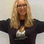 Lisa Kudrow in the black printed, full sleeves shirt while smiling towards camera and poses for a photo