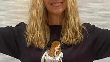 Lisa Kudrow in the black printed, full sleeves shirt while smiling towards camera and poses for a photo