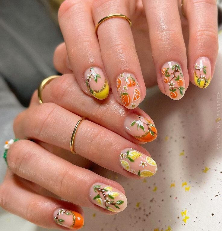 Short nails with fruit nail art using orange, yellow, and pink nail paint