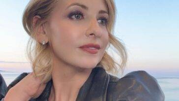 Sarah Michelle Gellar in the black jacket and diamond studs while poses for a photo