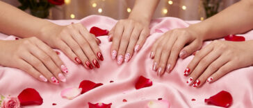 Valentine's nails 2026 featuring romantic pink hearts, red chrome, cherry blossoms, rose gold glitter, and classic heart designs on pink silk with rose petals